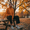 Woman sitting on a picnic table in an autumn park