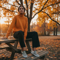 Woman sitting on a picnic table in an autumn park