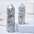 Two natural crystal stones with a blue rough texture, placed on a white surface with a decorative flower and a cup in the background.