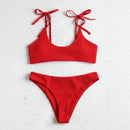 Red bikini set with tied straps on a light gray background