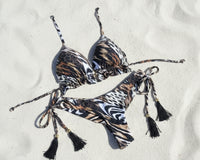 Leopard print bikini set on a white sand beach