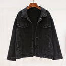 Black denim jacket on a hanger against a white background