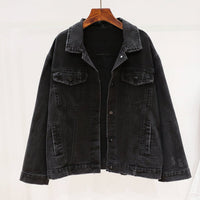 Black denim jacket on a hanger against a white background