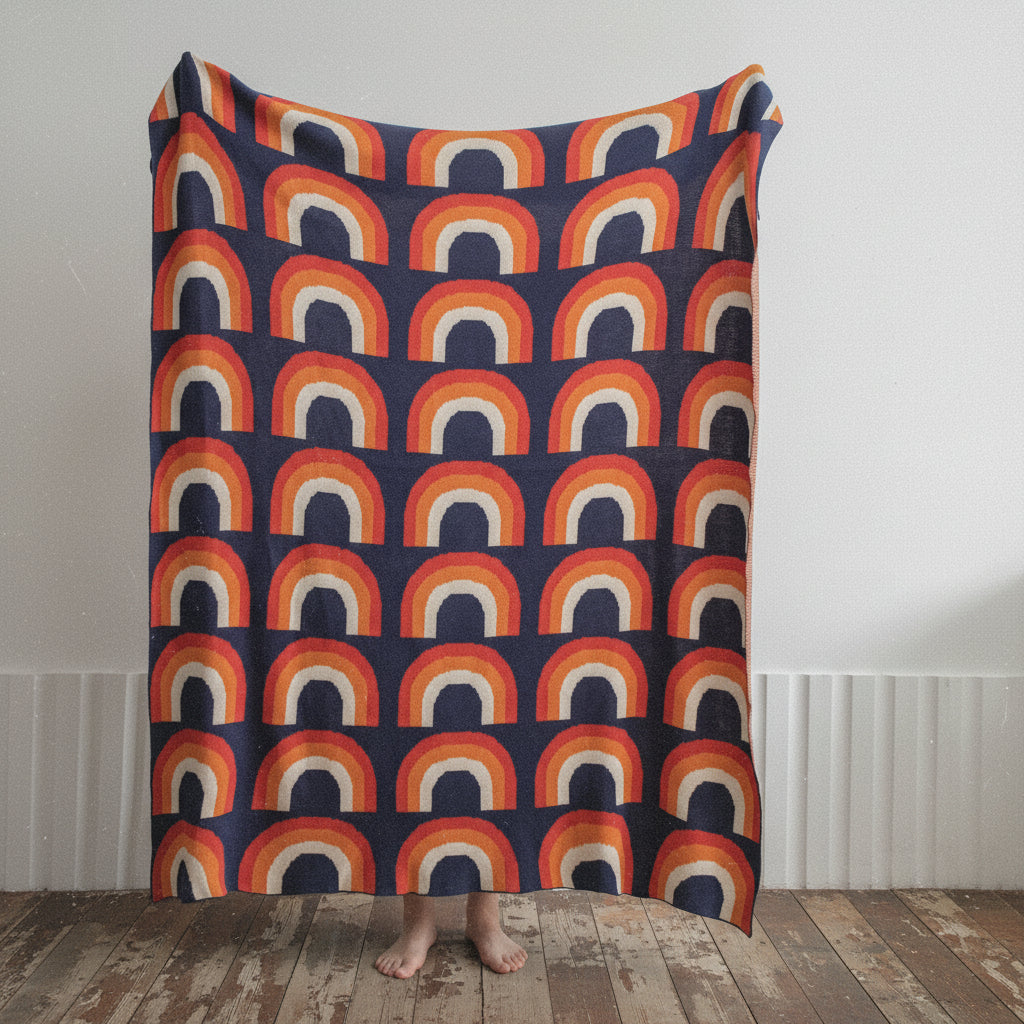 A Nordic cotton wool nap blanket with a colorful geometric pattern, draped over a chair in a cozy setting.