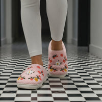 Pink slippers with floral embroidery on a light background