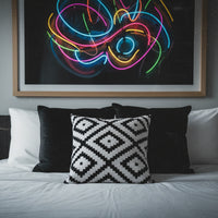 Black and white geometric patterned pillow on a white background