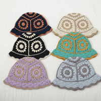 Set of six colorful crocheted hats on a white background