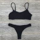 Black bikini set on a wooden surface with a starfish.