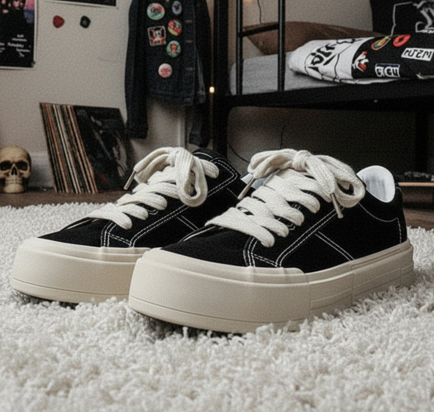 Black sneakers with white soles on a metal bench, featuring 'Fashion Lauridsen' branding.