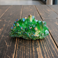 Green crystal cluster on a wooden surface