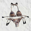 Leopard print bikini set with tassels on a white sand 