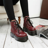 A pair of women's round toe front lace up boots in a wine red color, with high-tops and lace-up closure.