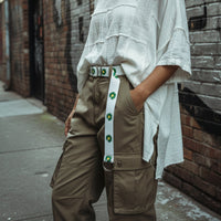 White belt with green floral patterns on a white fabric background