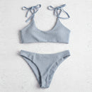 Light blue bikini set on a textured white background