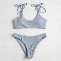 Light blue bikini set on a textured white background