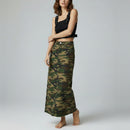 Woman wearing a black top and camouflage skirt on a gray background