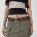Person wearing a striped sweater and cargo pants with a decorative belt on a white background