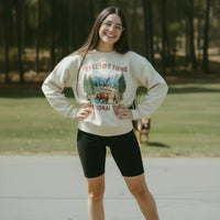 Beige sweatshirt with Yellowstone National Park graphic on a hanger against a white background