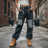 Person wearing patchwork jeans against a dark background