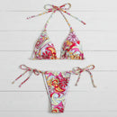 Colorful patterned bikini set on a light wooden surface