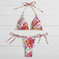 Colorful patterned bikini set on a light wooden surface