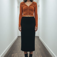 Orange long-sleeve top and black skirt set on a white background