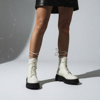 Pair of beige boots on a light white background