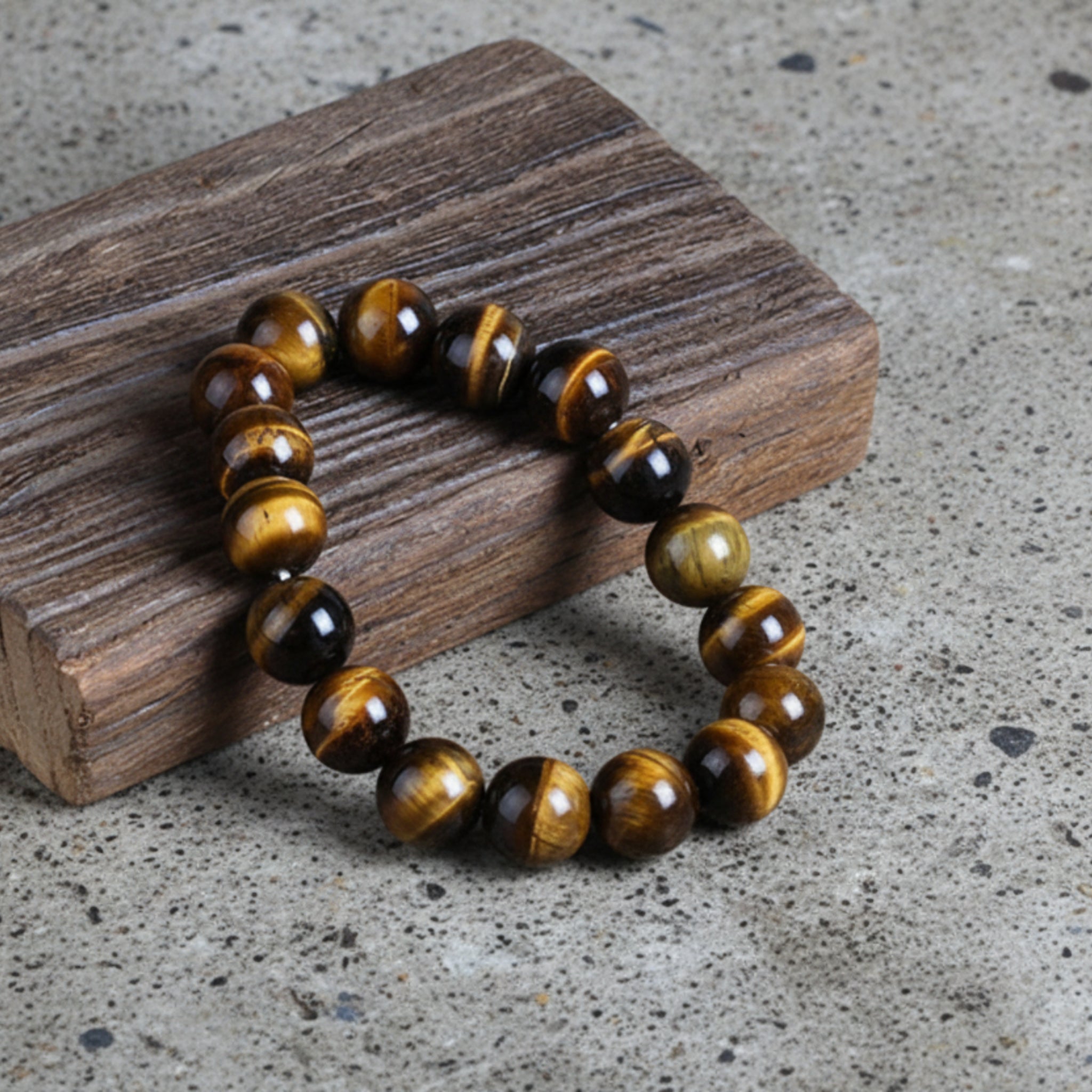 A round natural stone bracelet with a mix of brown and black agate beads, displayed on a wooden surface.