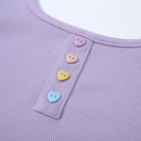 Close-up of a purple garment with colorful heart-shaped buttons.