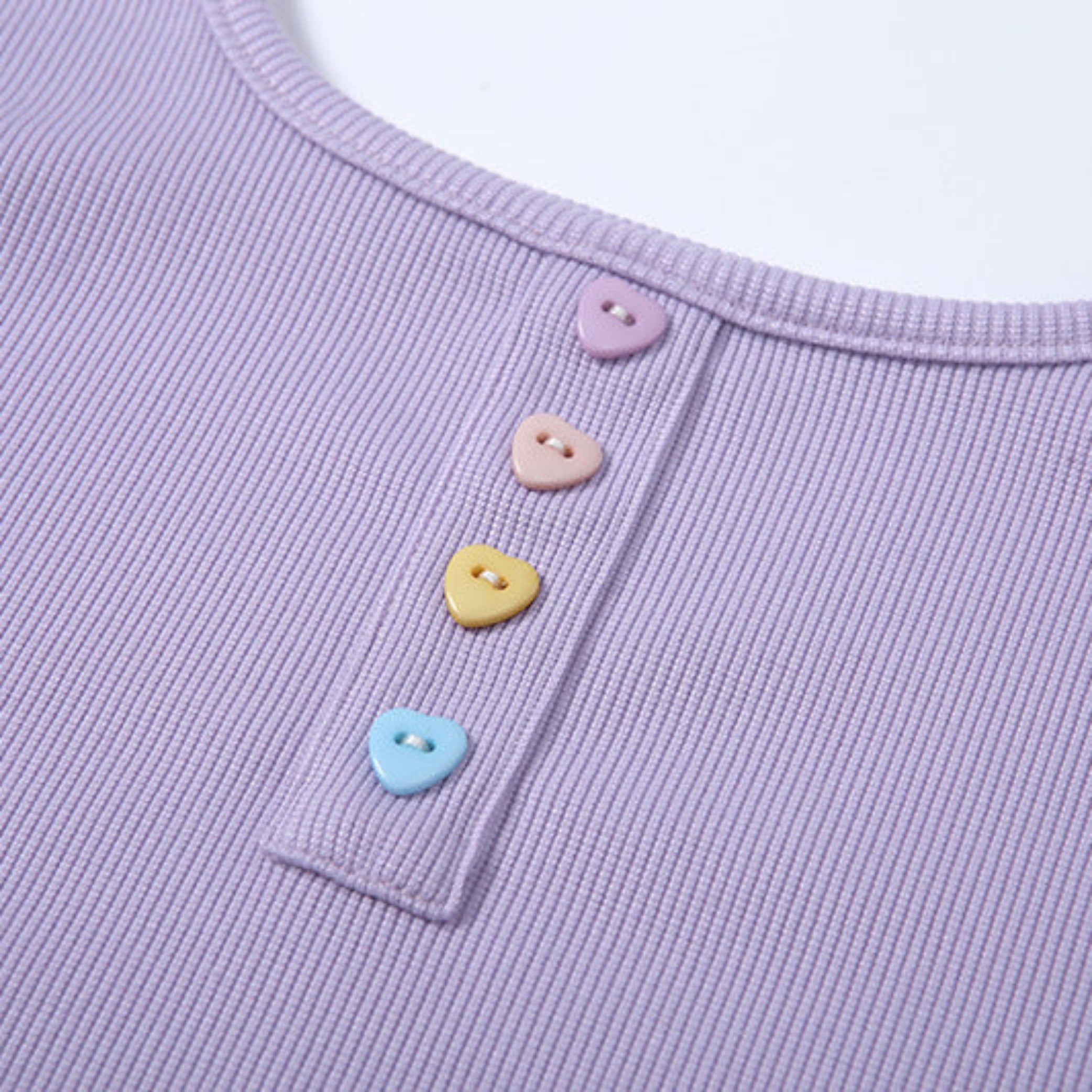 Close-up of a purple garment with colorful heart-shaped buttons.