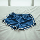 Blue shorts with white trim on a light gray background