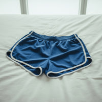 Blue shorts with white trim on a light gray background