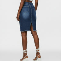 Person wearing a blue denim skirt with a blurred background