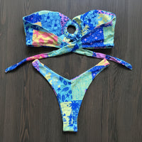 Colorful bikini set with floral patterns on a dark surface.