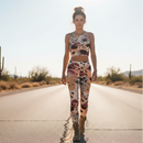 Woman in a patterned outfit standing on a road with cacti in the background