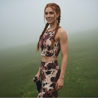 Woman wearing a camouflage sports outfit standing on grass