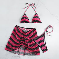 Pink and black patterned bikini set on a light gray background