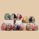 Collection of colorful woven bags with tassels on a beige background