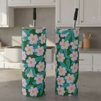 Three floral-patterned tumblers with straws on a white background