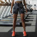 Person wearing black and gray tie-dye shorts with a neutral background