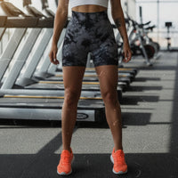 Person wearing black and gray tie-dye shorts with a neutral background