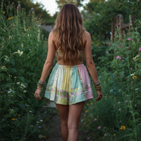 Person wearing a patchwork skirt with floral patterns in a natural setting