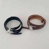 Two leather bracelets with silver clasp on a light gray background