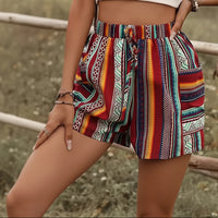 Colorful patterned shorts worn by a person with a blurred natural background