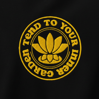 Embroidered design on a black background with yellow text and lotus flower symbol.